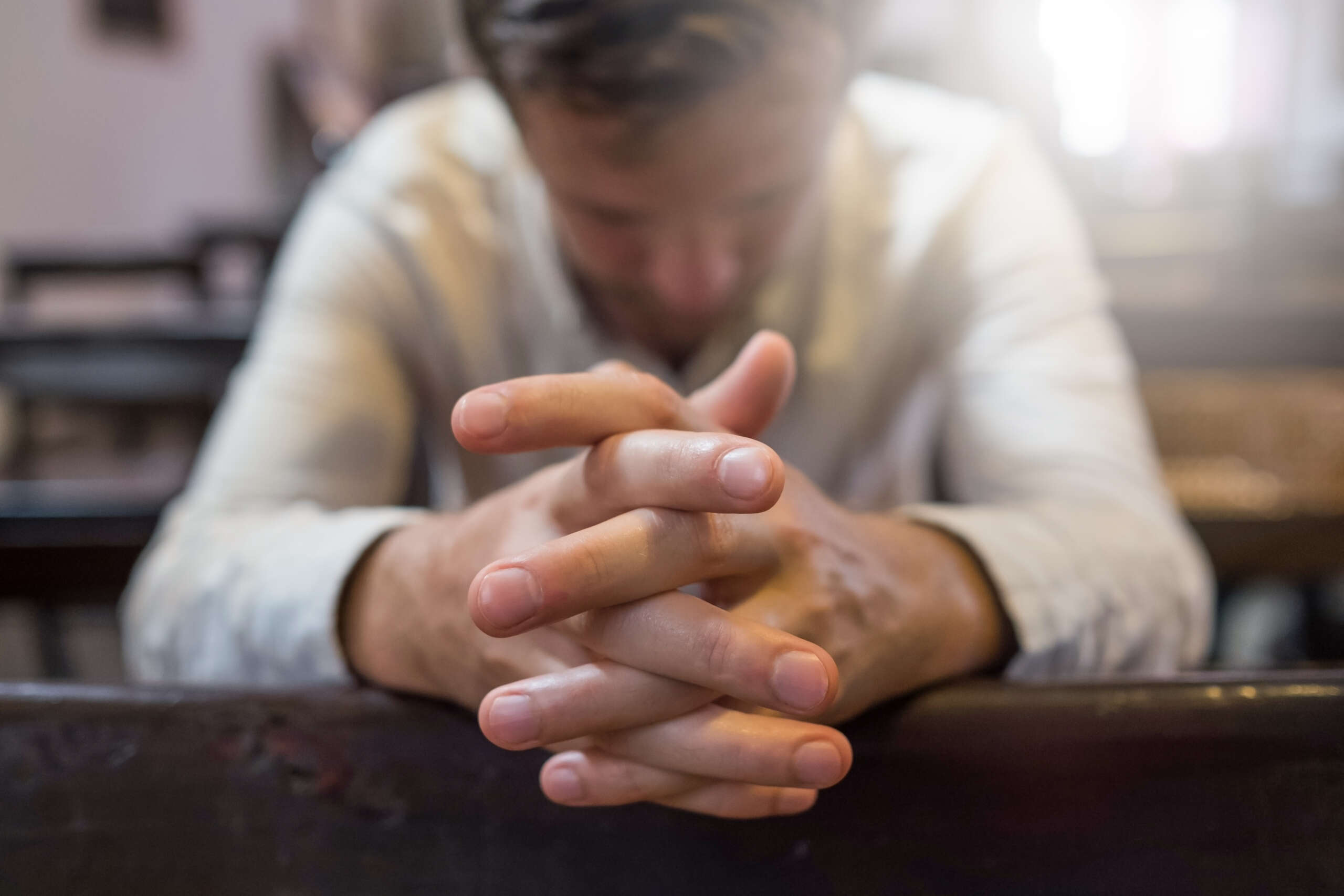 man praying in church- faith based treatment