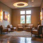 a serene, inviting counseling room in an arkansas recovery center, featuring warm lighting, comfortable seating, and emotionally resonant artwork that reflects the theme of healing and personal transformation.