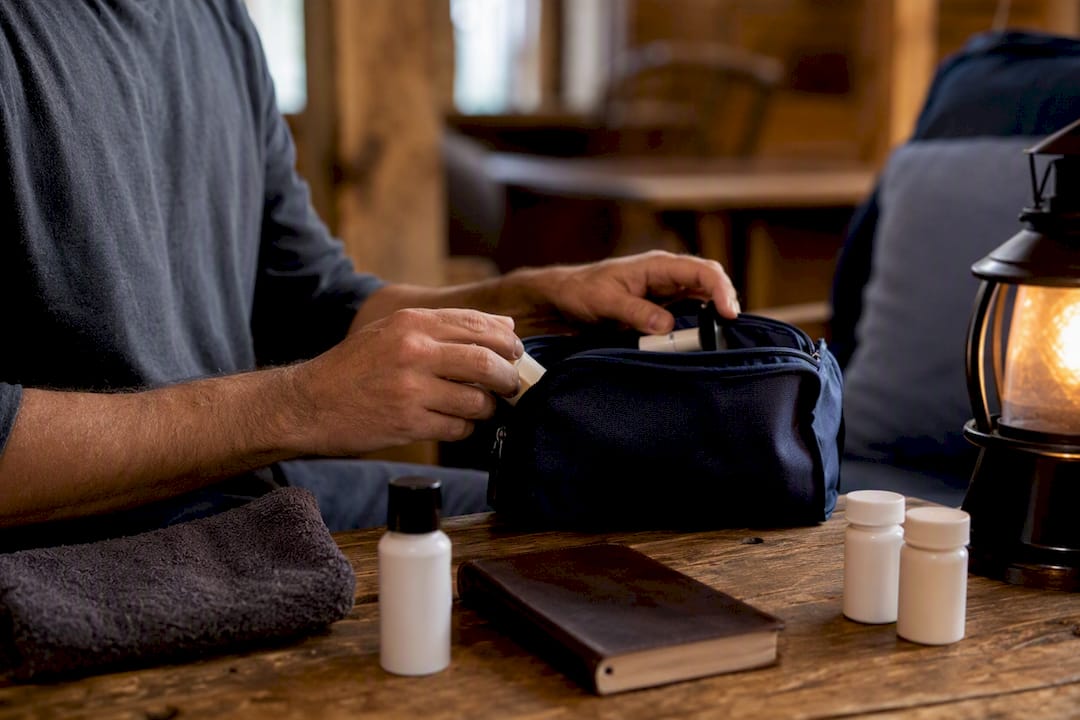 Hands packing carry bag with toiletries