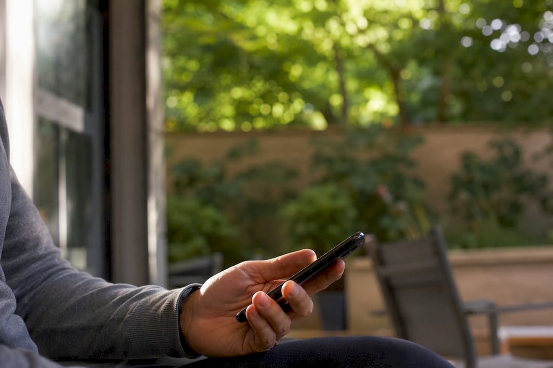Partial view of man holding smartphone